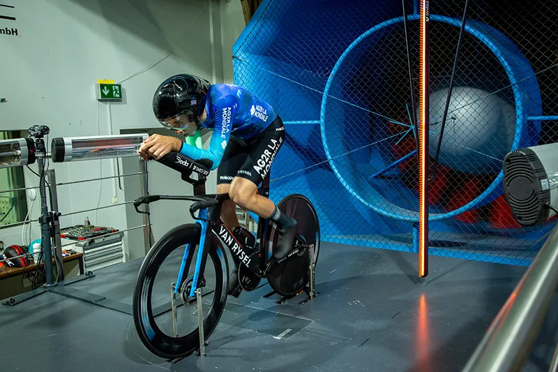 Ciclista realizando pruebas de aerodinámica en túnel de viento bajo la supervisión de Luis Lamas Vázquez, Biomecánico Deportivo y Mecánico del equipo Decathlon – CMA CGM